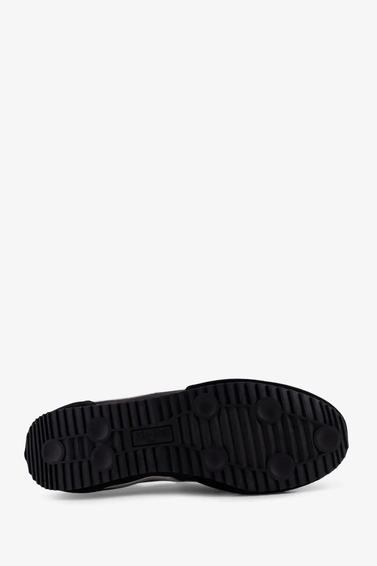 Black rubber sole with textured tread and circular grip patterns on pro-keds men’s racer sneakers in suede and nylon black
