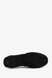 Black rubber sole with textured tread and circular grip patterns on pro-keds men’s racer sneakers in suede and nylon black