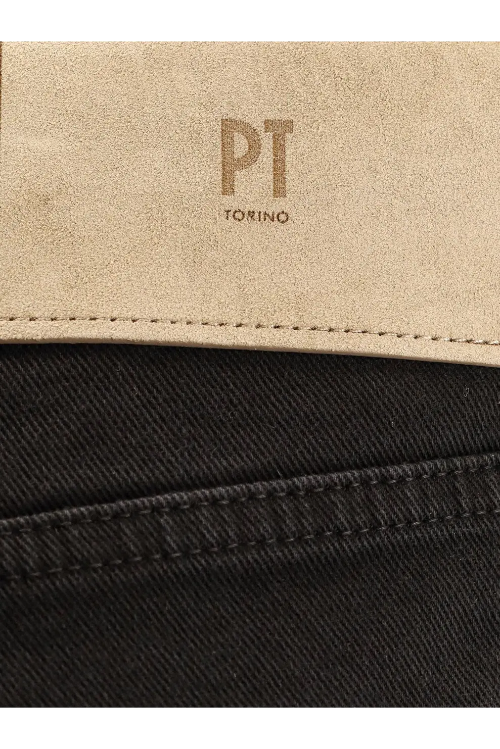 Beige suede patch with embossed pt torino logo stitched on the back of men’s black denim jeans black