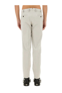 Beige cotton pt torino men’s chinos with tailored fit and black buttoned back pockets shown from the back side