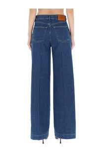 Dark blue wide-leg denim trousers with brown leather brand patch on waistband pt torino women’s jeans poppy blue back view