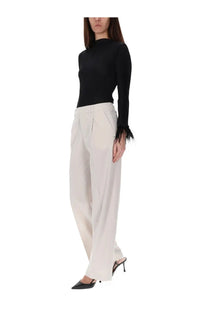 Black long-sleeved knit top with feathered cuffs paired with pt torino women’s pink pants lola model
