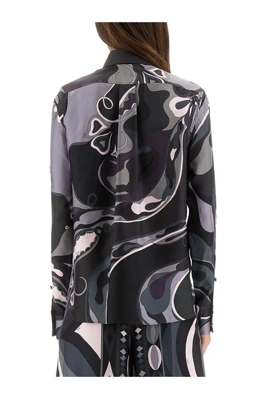 A woman wears a pucci women’s orchid print long-sleeved silk blouse in black gray and soft pink abstract pattern