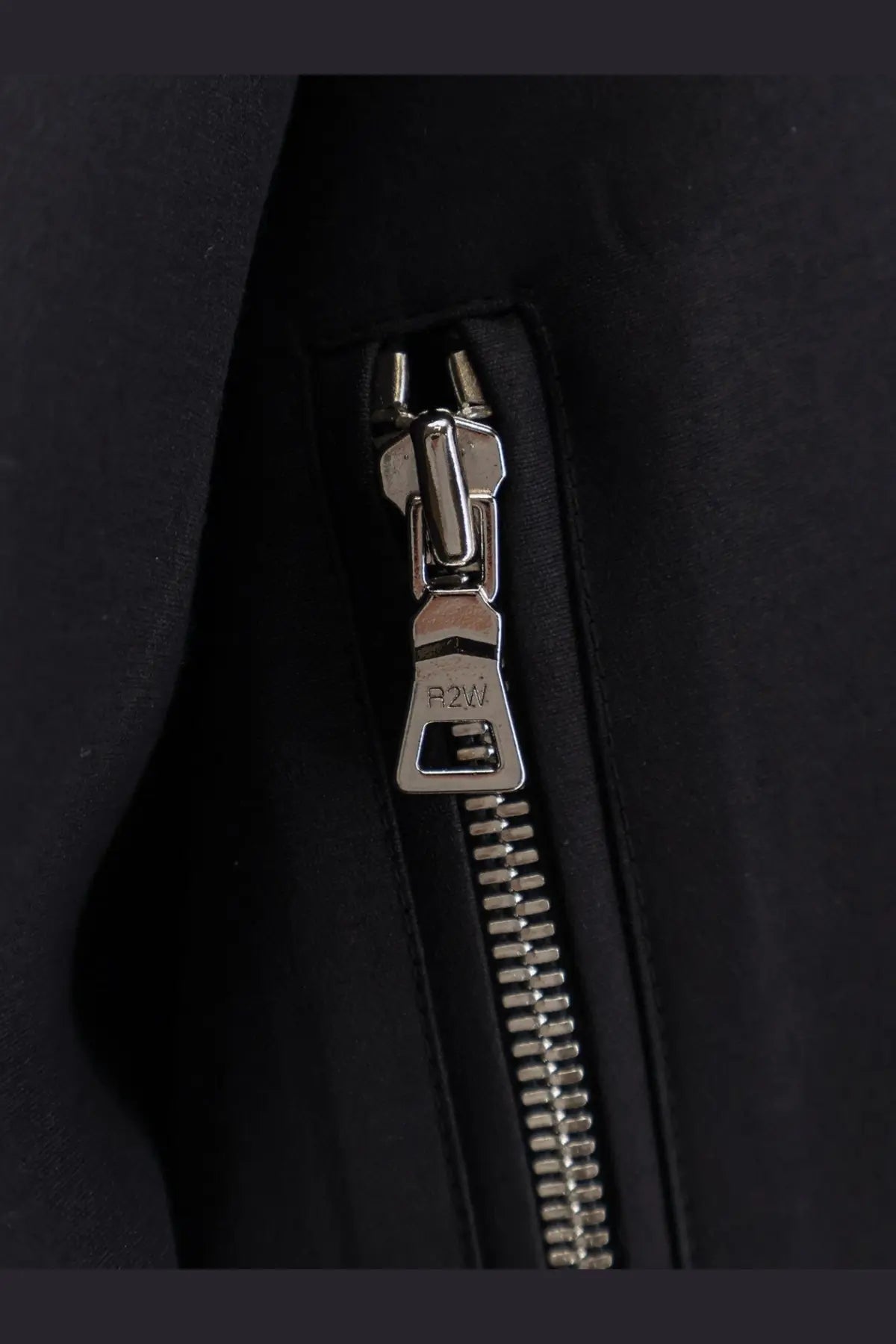 Silver-toned zipper pull with p2w engraving on r2w women’s julio black wool and silk jacket