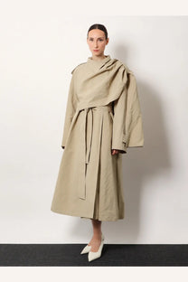 Beige trench coat with draped asymmetrical design and matching belt made of linen and cotton by r2w women’s lumira