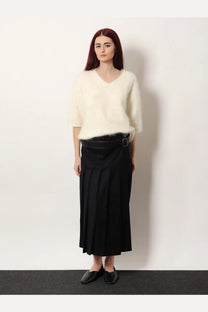 Cream-colored fluffy v-neck short sleeve wool sweater paired with R2W women’s nayla pleated black wool trousers skirt