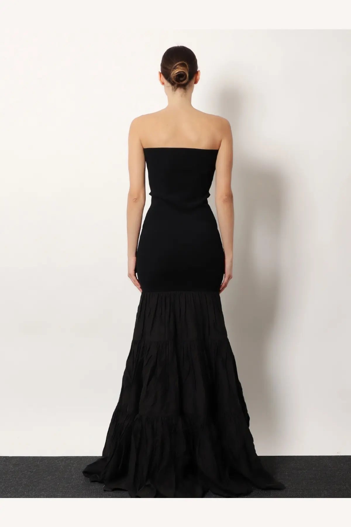Black strapless mermaid gown by R2W with fitted bodice and tiered flowing skirt in elegant black fabric
