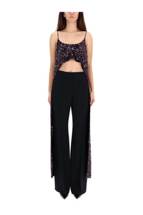 Rabanne women’s dark purple sequined crop top with thin straps and cape-like sides paired with black trousers