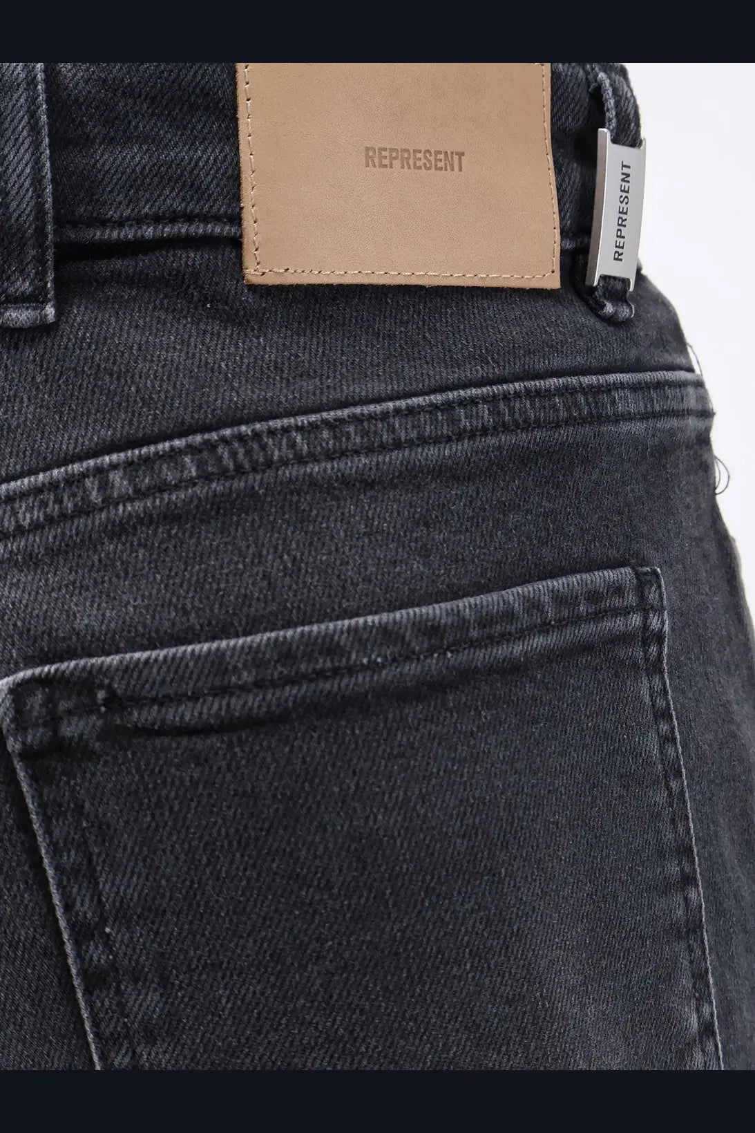 Dark-wash denim represent men’s boot cut jeans black with tan leather brand patch and silver tag embroidered represent