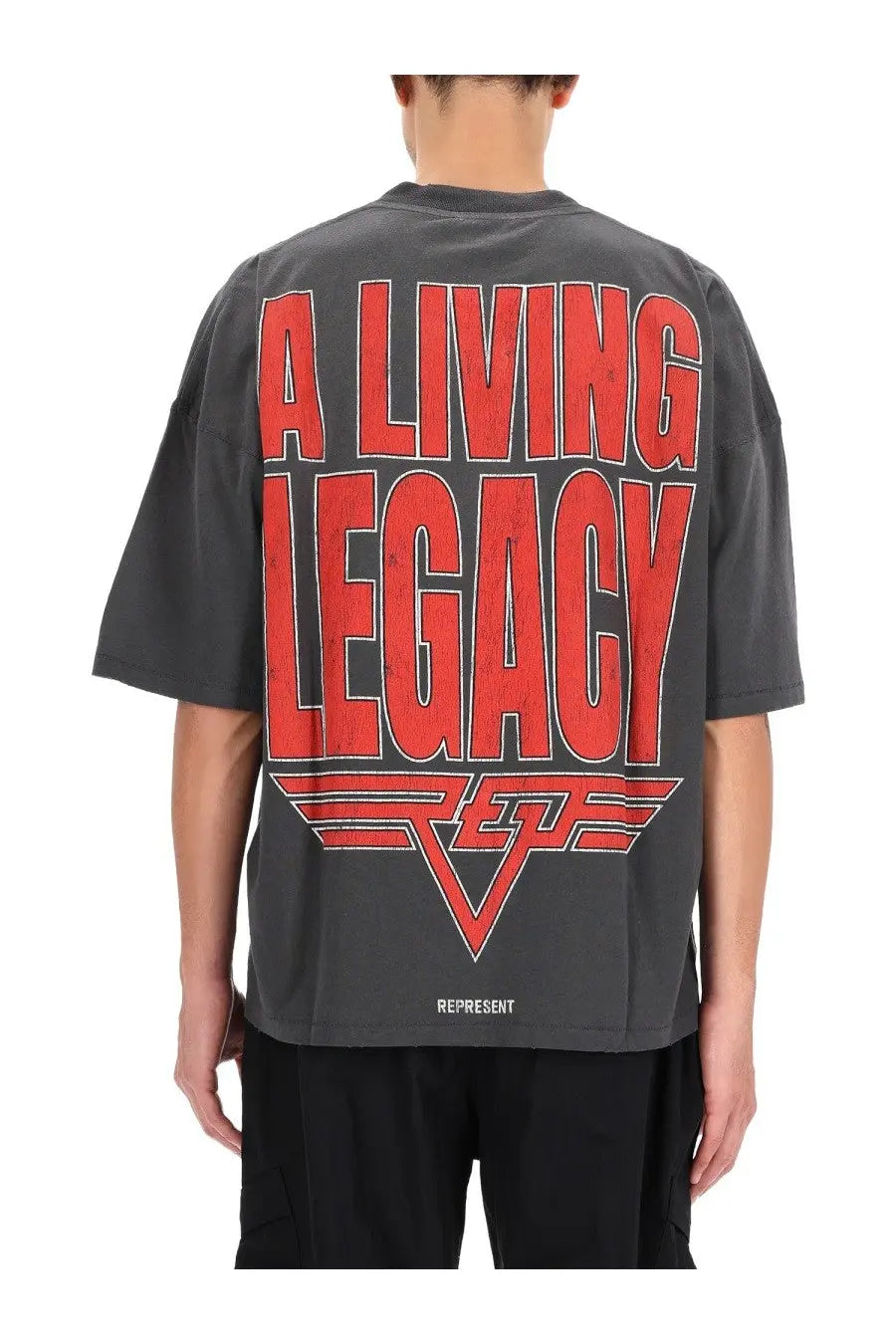 Dark gray oversized represent men’s living legacy shirt with bold red text and white logo print at the bottom hem
