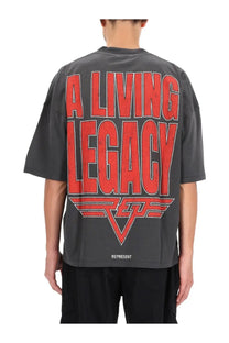 Dark gray oversized represent men’s living legacy shirt with bold red text and white logo print at the bottom hem