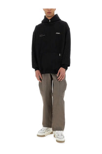 Represent men’s patron of the club hoodie black with subtle white logo embroidery and small brand tag near the collar