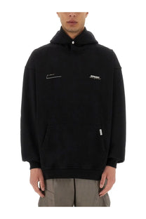 Black hooded sweatshirt with white embroidered logo and signature on chest front pocket and ribbed cuffs by Represent
