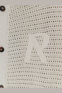 Beige knitted cardigan with perforated texture and embroidered r logo paired with represent men’s pico cotton blend polo shirt white