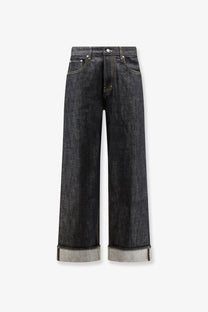 Dark-wash straight-leg denim jeans with rolled cuffs revealing lighter fabric paired with represent men’s selvedge denim shirt black