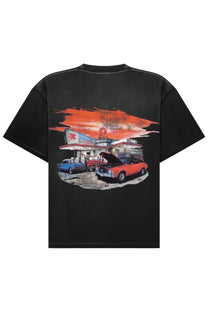 Black oversized cotton t-shirt with vintage cars graphic at retro gas station under orange sky from Represent Men