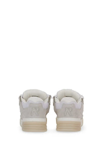 Off-white suede represent men’s studio sneakers showing the back with subtle embossed r logo on the heel