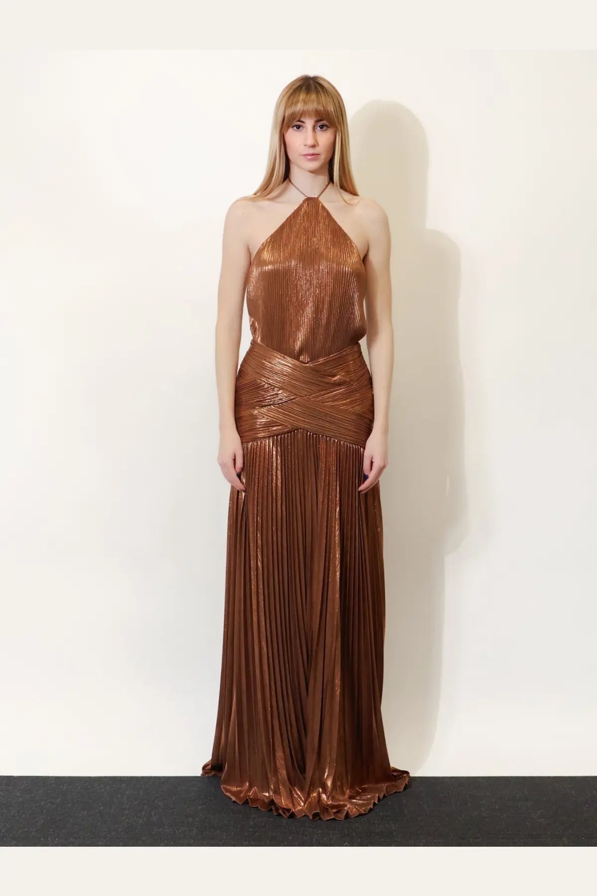 A shimmering bronze pleated halter neck gown with a draped waistband from Retrofete women’s amberley dress sepia