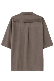 Back view of a taupe grey Rick Owens men’s magnum tommy short-sleeved shirt with structured collar and horizontal back strap