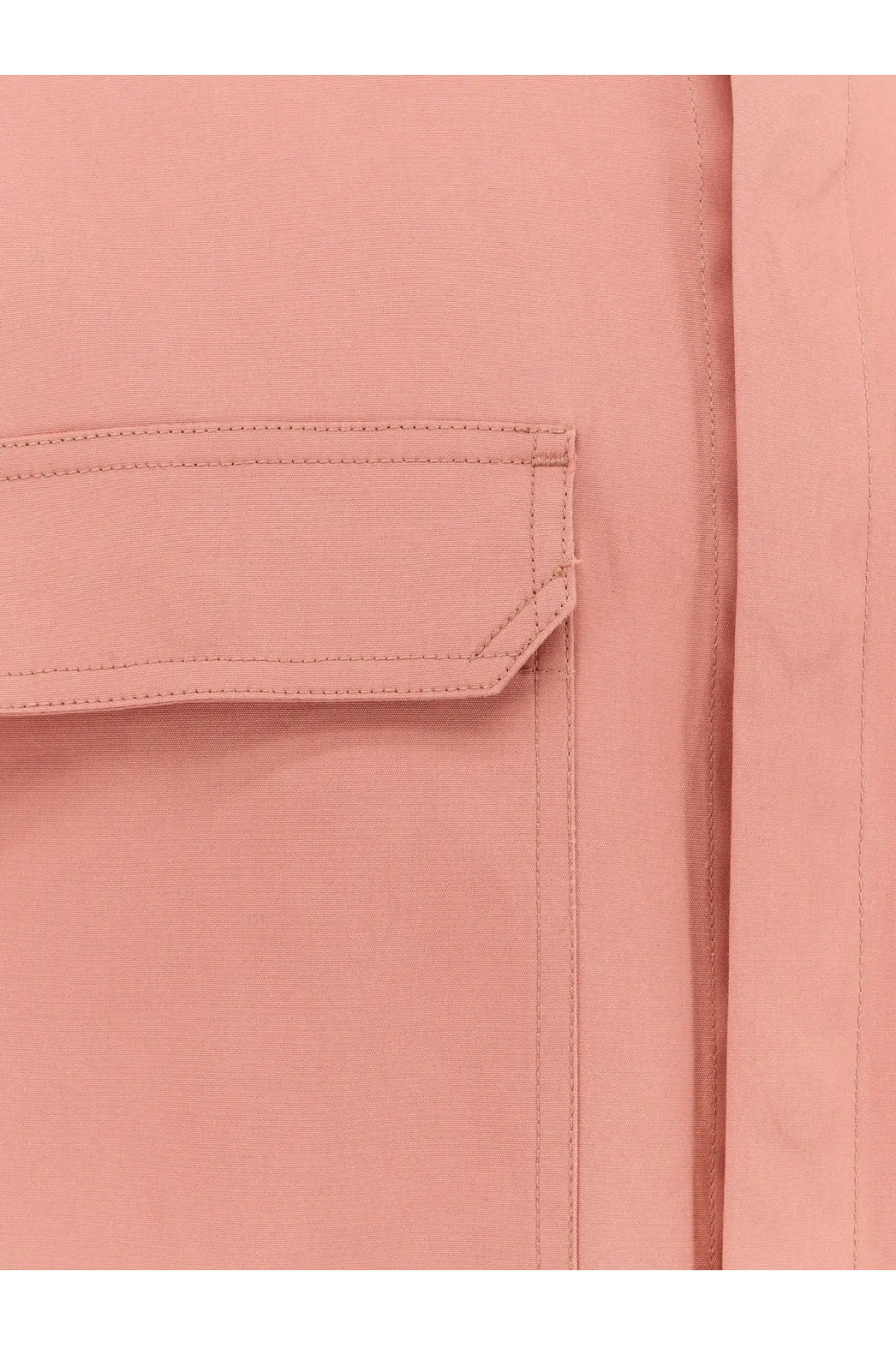A soft pink fabric pocket with neat stitching on a rick owens men’s organic cotton shirt orange
