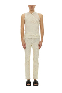 A cream-colored sleeveless top with draped crisscross neckline and ruching paired with rick owens white utility pants
