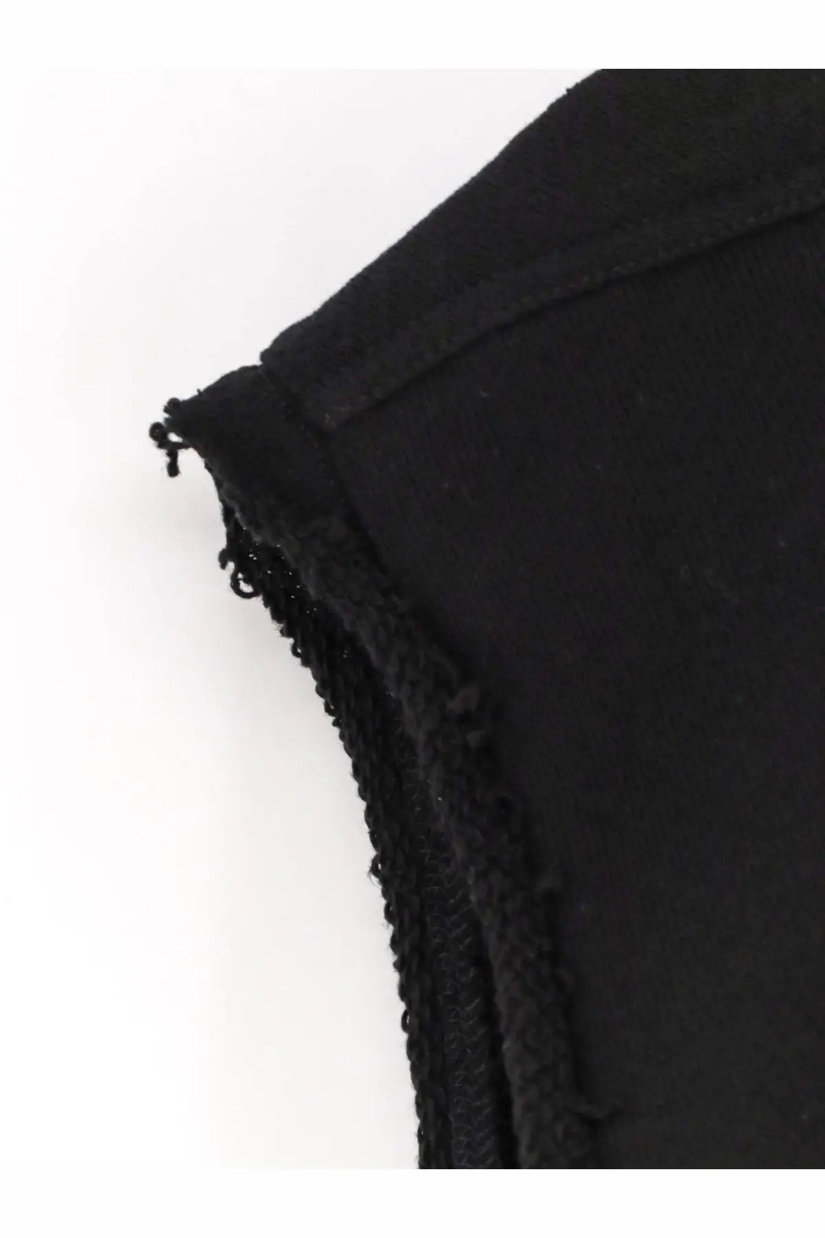 Black fabric close-up of the frayed textured edge of rick owens men’s sleeveless organic cotton sweatshirt black