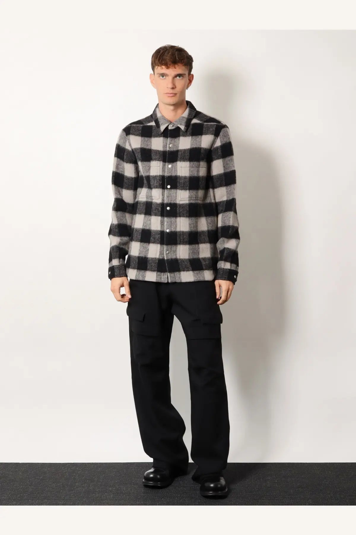 Black and gray plaid flannel shirt with button-down front paired with rick owens men’s stefan cargo virgin wool trousers black
