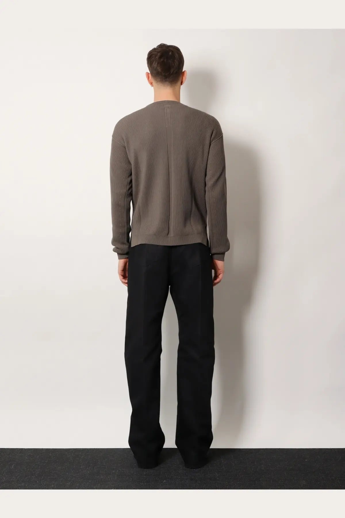 Back view of a ribbed muted gray virgin wool knit sweater with central seam by Rick Owens men’s collection