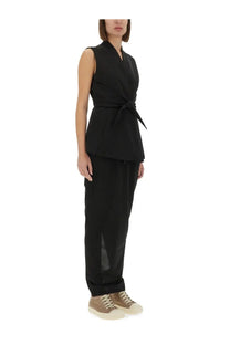 Black sleeveless wrap vest with tied waistband and subtle side slit complementing rick owens women’s pillar skirt