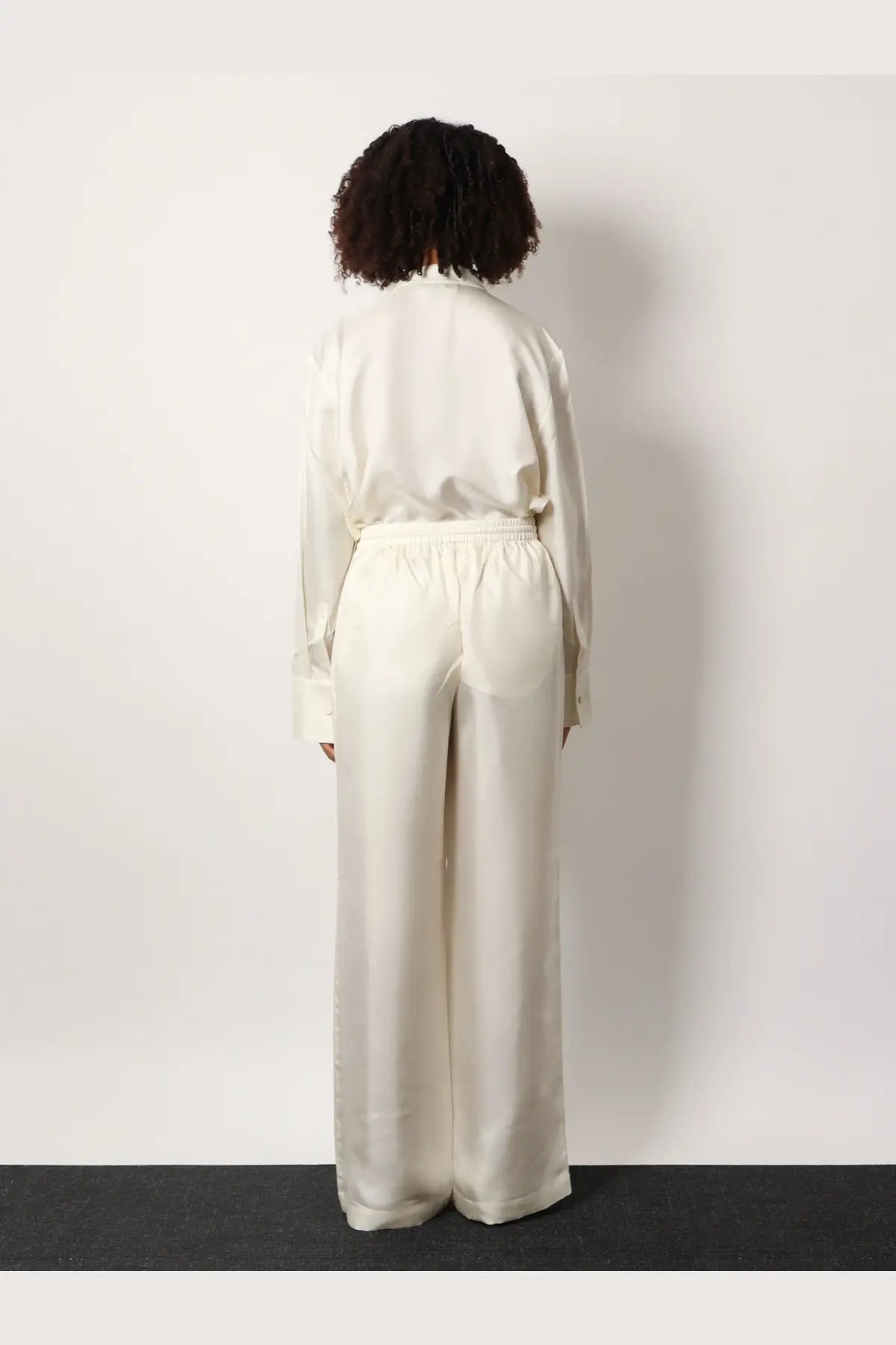 Rohe women’s jogger silk trousers in cream-colored satin with relaxed wide-leg cut and elastic waistband