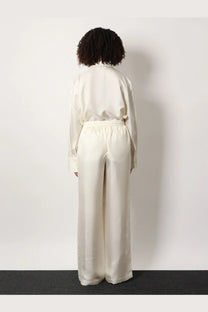 Rohe women’s jogger silk trousers in cream-colored satin with relaxed wide-leg cut and elastic waistband