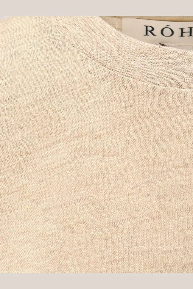 A soft heathered beige crewneck t-shirt with subtle texture and a branded róh tag, styled for women