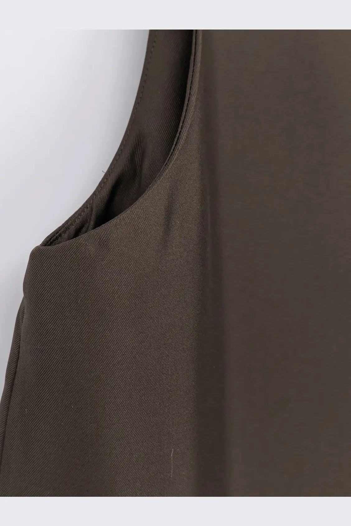 A sleek olive green sleeveless top with smooth textured fabric and clean stitching from Rohe women’s long silk dress earth