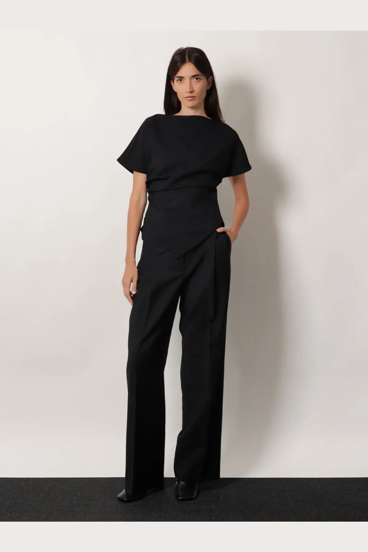 Black minimalist jumpsuit with short flutter sleeves and wide-leg trousers in wool blend fabric