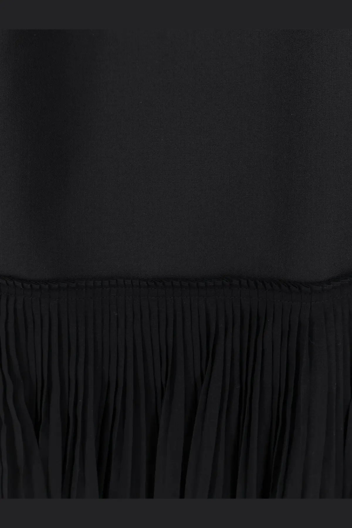 Black pleated fabric hem of rohe womens pleated long dress showcasing elegant flow and texture
