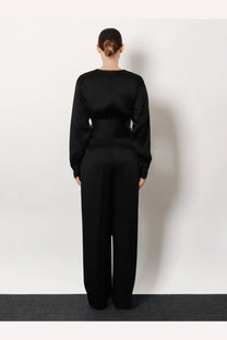 Black satin jumpsuit with long sleeves and wide-leg pants from rohe women’s relaxed satin trousers collection