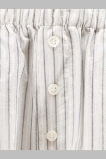 White buttons with subtle sheen on rohe womens silk trousers featuring fine vertical light gray and white stripes fabric