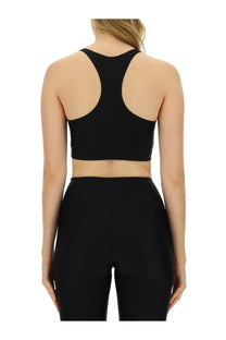 Back view of black racerback sports bra with cutout design from rotate birger christensen women’s crop top collection