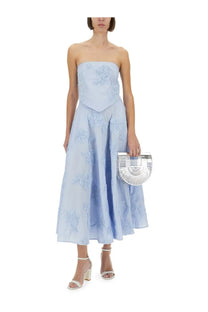Silver fan-shaped clutch with u-form handle and sleek modern design paired with rotate birger christensen blue maxi skirt