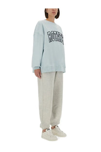 Light blue oversized sweatshirt with rotate print paired with Rotate Birger Christensen women’s grey track pants
