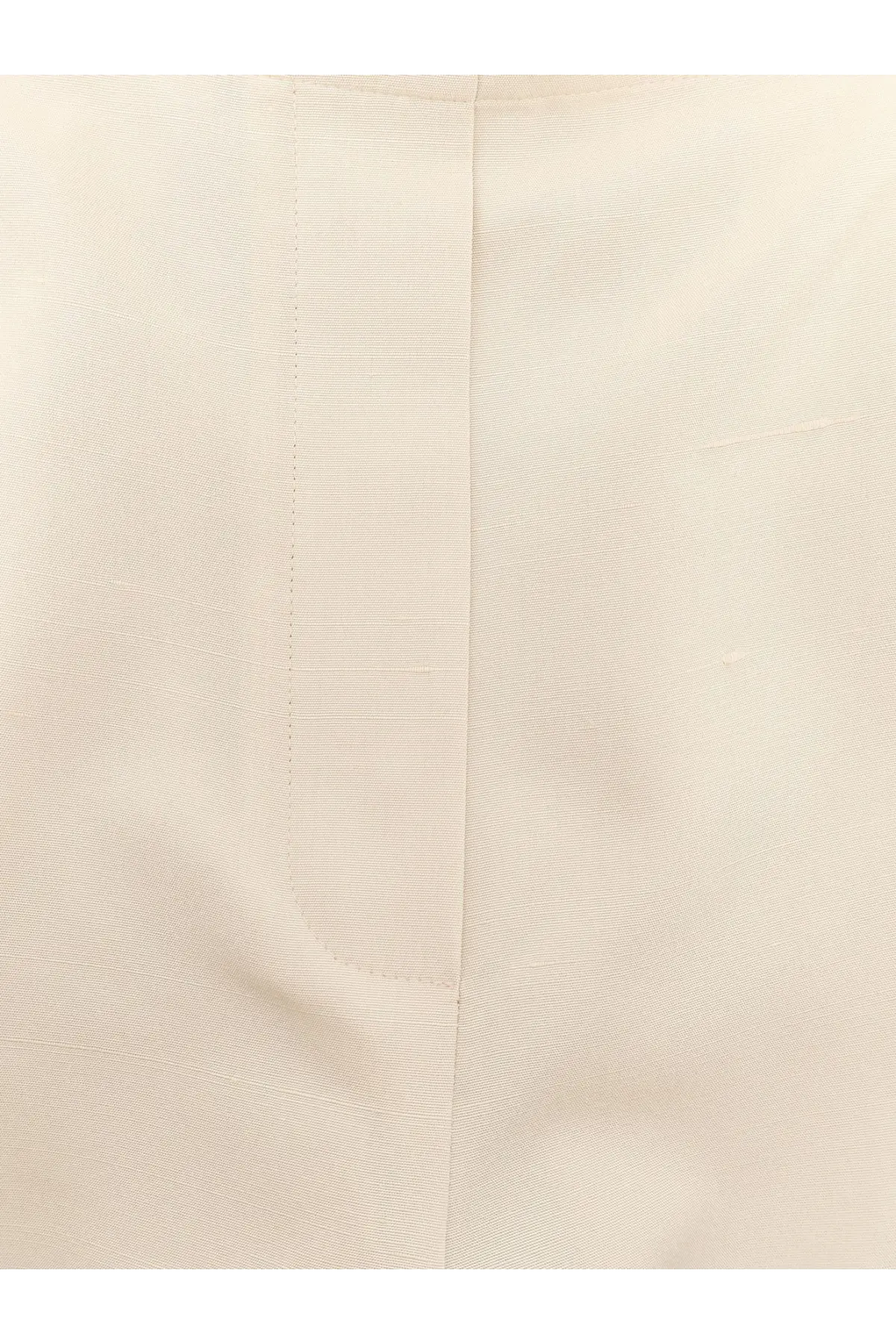 Cream-colored cotton shirt with subtle ribbed texture and neat stitching paired with the row women’s beta silk trousers white