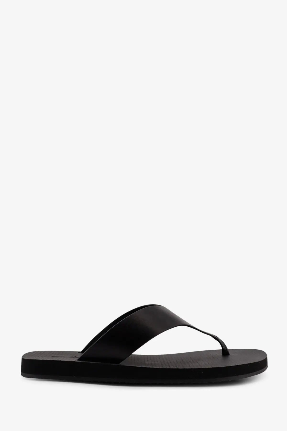 Black leather flip-flop with sleek minimalist design and flat rubber sole from the row women’s dune classic ginza sandals