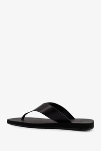 Black leather thong sandal with minimalist design and smooth matte finish from the row women’s dune classic ginza collection