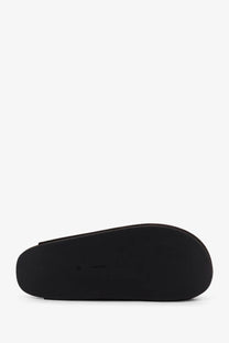 Black rubber sole of the row women’s hudson two brown suede minimalist slide sandal shown from the back