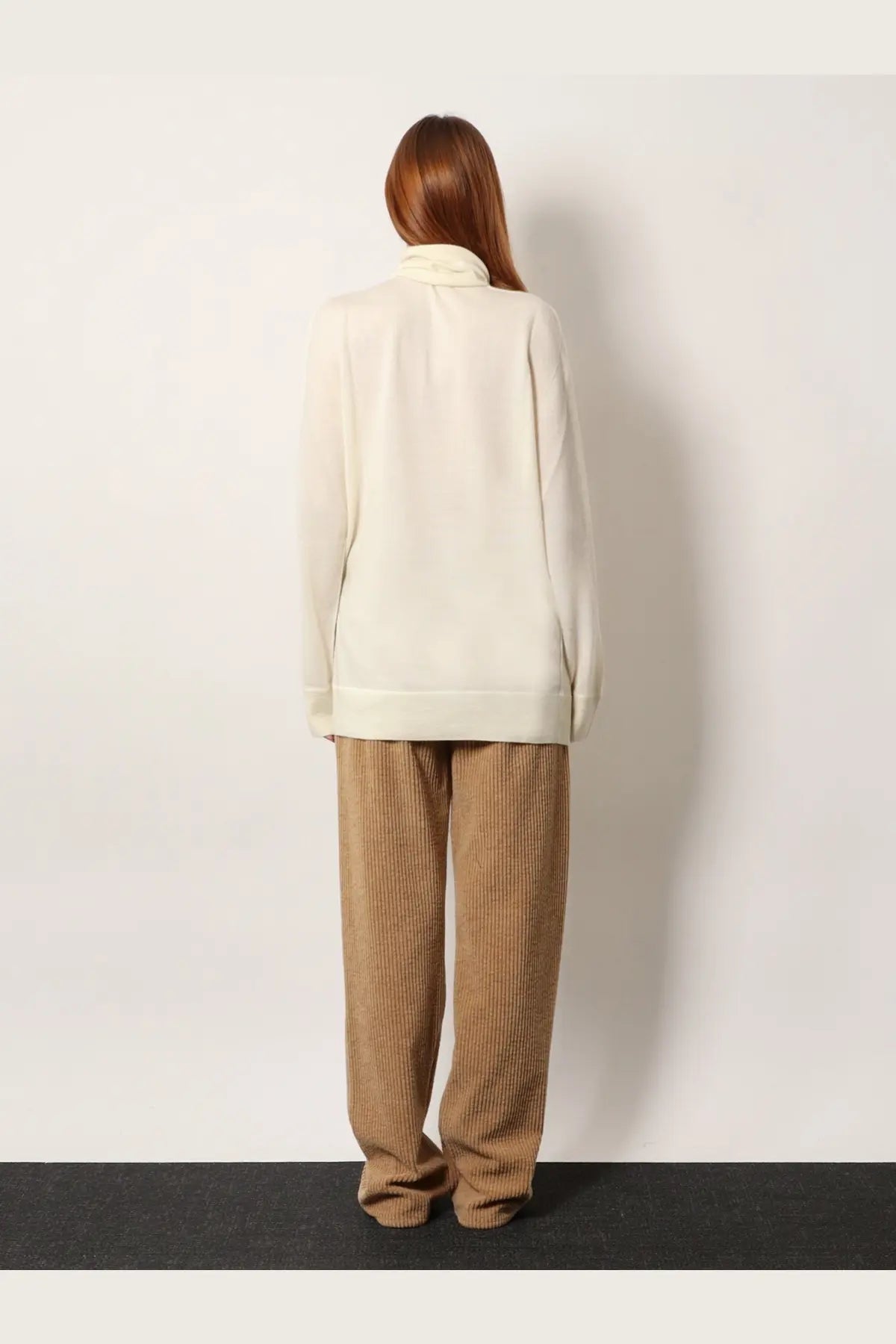 The row women’s lizzy cashmere top white is a cream-colored long-sleeved sweater with a soft high collar