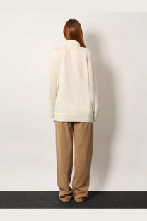 The row women’s lizzy cashmere top white is a cream-colored long-sleeved sweater with a soft high collar