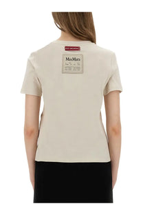 Back of beige s max mara women’s bud shirt with rectangular black text label patch and small red tag on cotton fabric