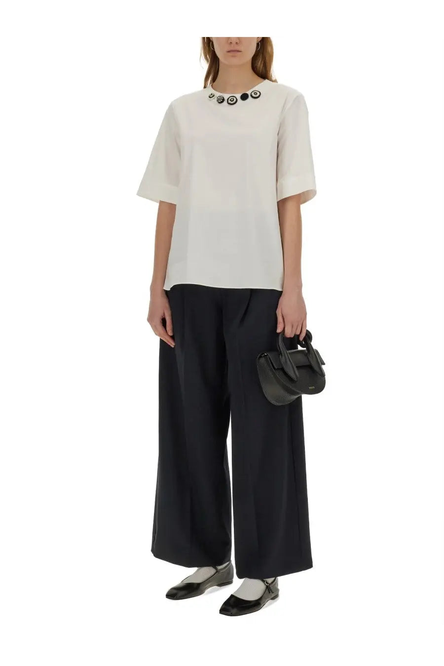 A minimalist off-white short-sleeved blouse with a decorative collar featuring black and white circular buttons paired with s max mara womens nichols blue pants