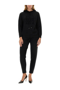 Black hooded sweatshirt with textured raised logo across chest paired with s max mara women’s pants opera black