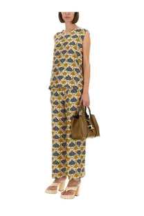 Olive green leather handbag with distinctive gold tone t shaped clasp shown with s max mara women’s silk multicolor pants